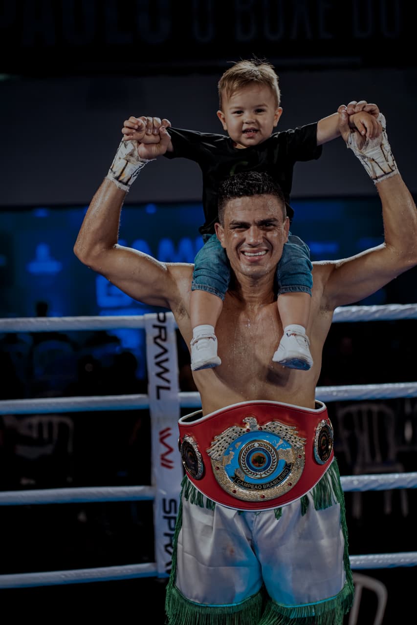 Laysson Canhoto comemorando vitória no ringue com o filho